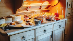 A breakfast buffet with various pastries, Nutella jars, and orange juice. - Garni Cir (Santa Cristina Val Gardena)
