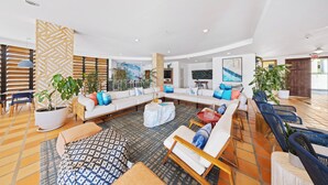 A spacious, well-lit living area with a large sectional sofa, multiple seating options, and potted plants. - Oceania 343 J.e. Irausquin Blvd 238 (Oranjestad)