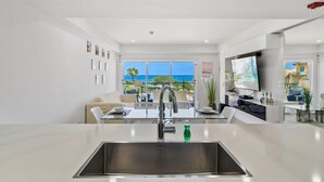 A modern kitchen with a large window, a dining area, and a TV. - Oceania 343 J.e. Irausquin Blvd 238 (Oranjestad)