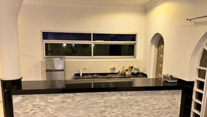 Una cocina moderna con encimera negra, salpicadero blanco y estufa integrada.