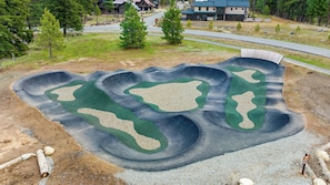 A large, landscaped area with multiple green patches and a winding path.