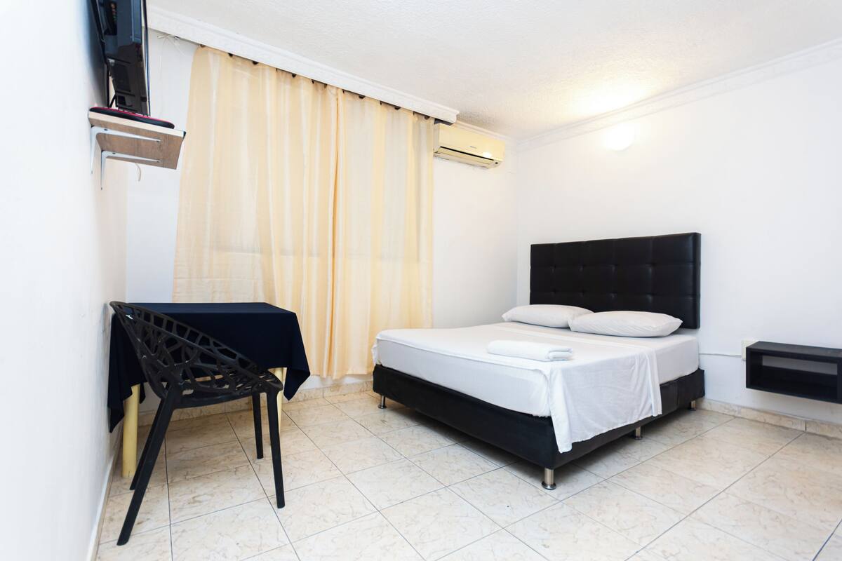 Ein Schlafzimmer mit einem Bett, einem Schreibtisch und einem Stuhl.
