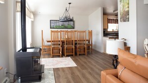 Una sala de estar con chimenea, mesa de comedor y sillas.