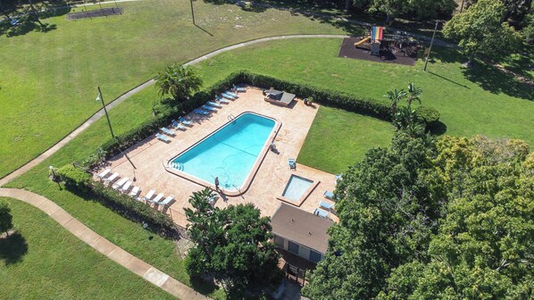 An aerial view of a residential property with a rectangular swimming pool surrounded by lounge chairs and a small deck area. - The Capri Villa Stay for 6 (Tampa)