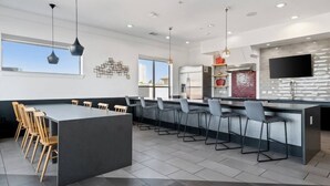 Una cocina moderna con una isla central, taburetes de bar y electrodomésticos integrados.