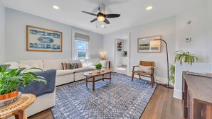 A modern living room with a sofa, coffee table, and a ceiling fan. - Cozy Farmhouse, Hot tub and Sauna on 8 acres! (Troutville)