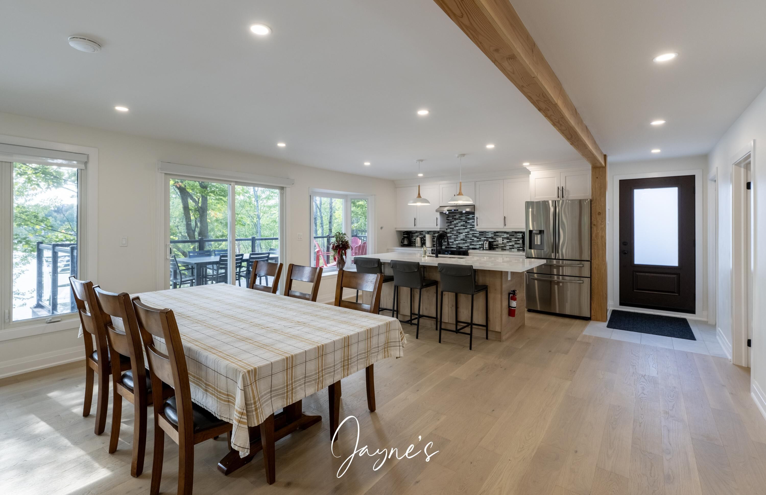 Une cuisine spacieuse dotée d’appareils électroménagers modernes, un coin repas avec une grande table et une vue sur l’extérieur.