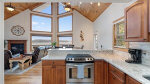 A spacious kitchen with a large island, wooden cabinets, and a stone countertop.