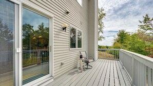 A wooden deck with a glass door and windows, a chair, and a small table. - Mtn Views, On-Site Trails! Spacious Bartlett Home (Bartlett)