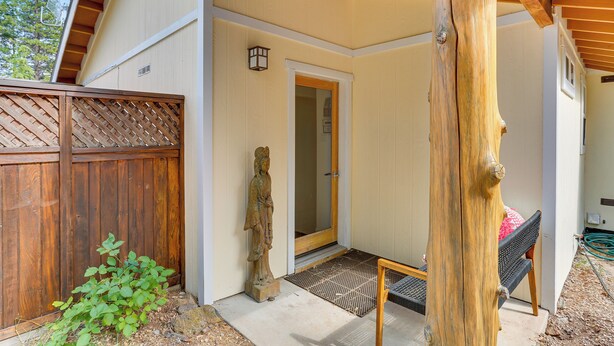 A covered outdoor area with a wooden bench, a statue, and a wooden fence. - Outdoor Adventure Haven - 15 Mi to Mount Shasta! (Weed)