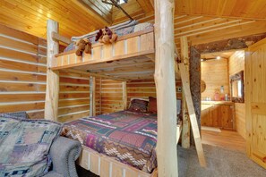 Una cabaña con literas, un pequeño espacio kitchenette y un interior de madera.