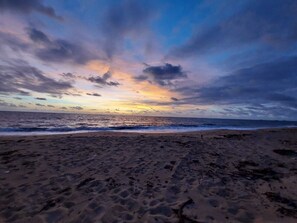 A beach with footprints leading to the water, a clear sky, and the ocean. - Cozy beach house with pool, in Aver o Mar, year-round sunshine. (Barra do Sirinhaém)