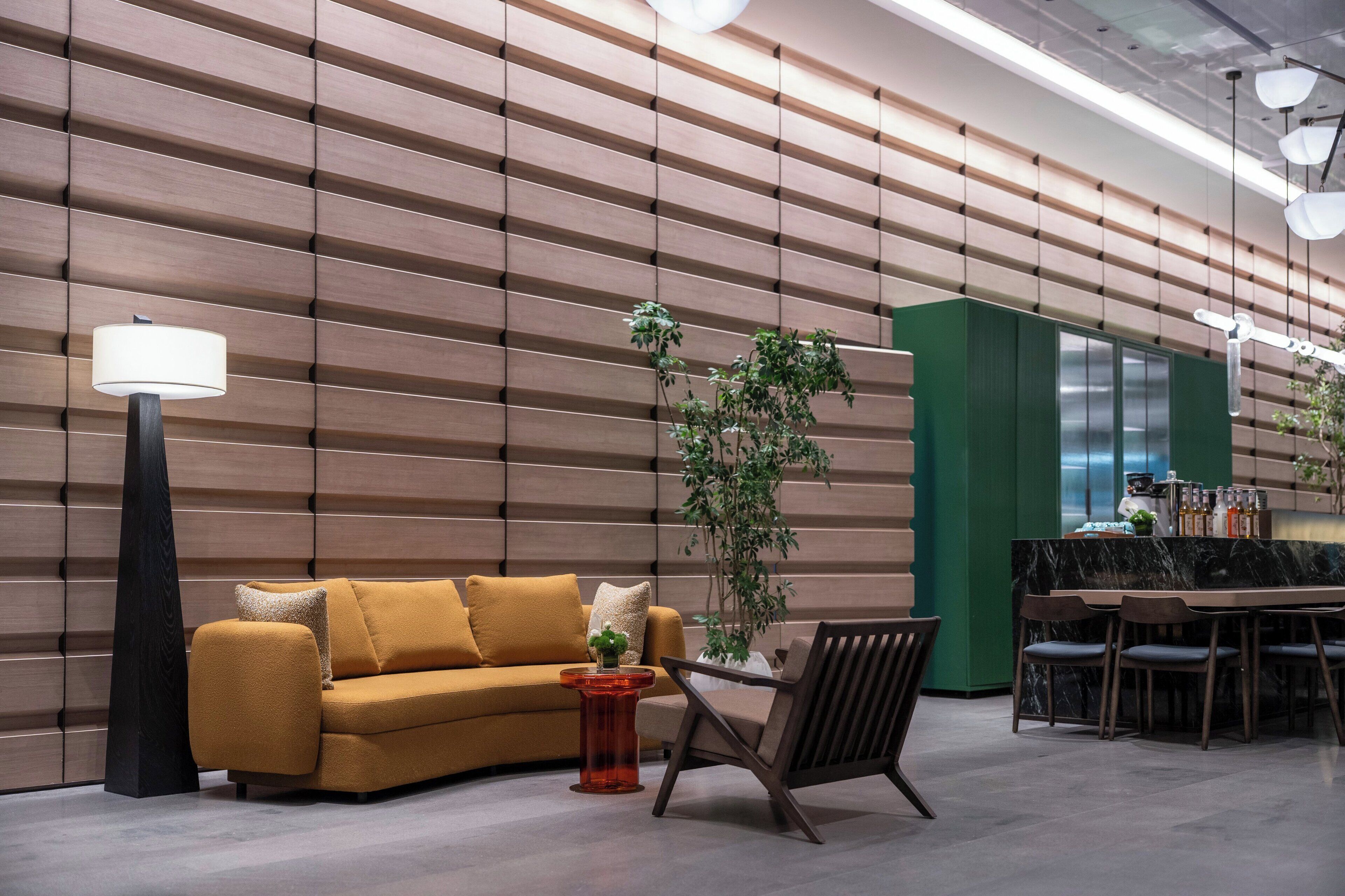 A modern interior with a sofa, a table, chairs, a lamp, and a green accent wall.