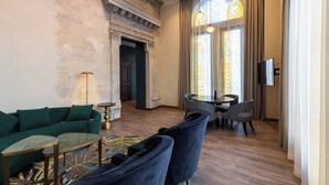 Ein modernes Wohnzimmer mit einem grünen Sofa, einem Essbereich mit Tisch und Stühlen sowie einem Kamin.