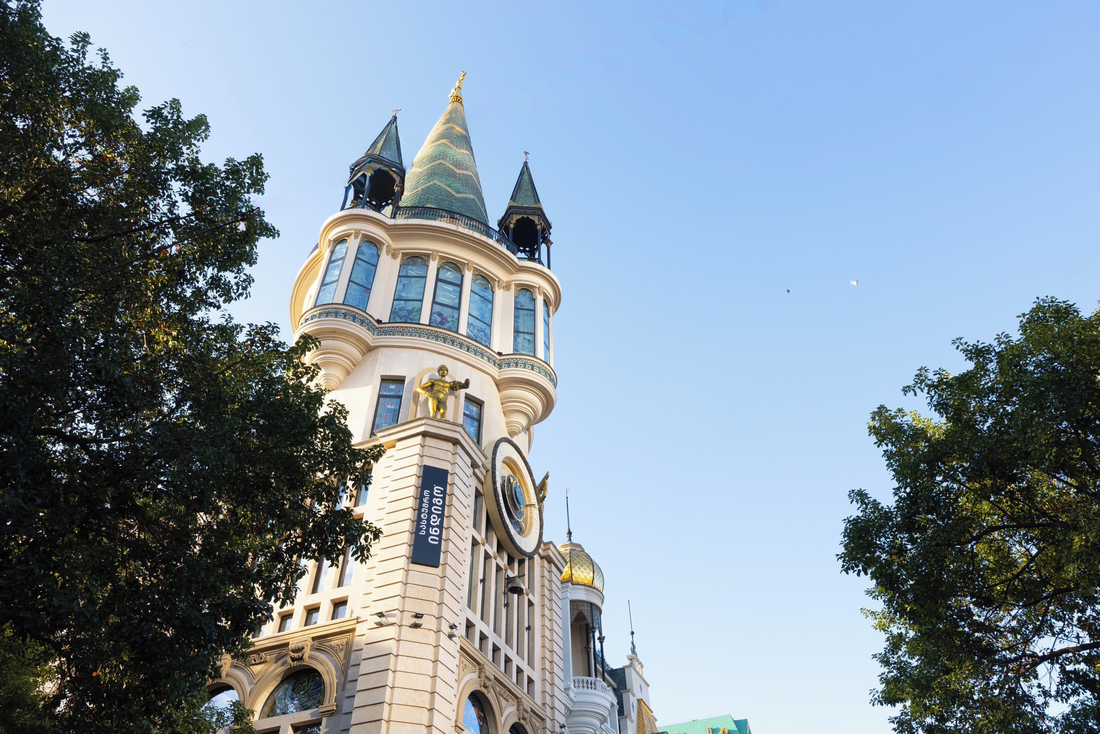 A historic building with ornate architecture, including a tower with a green dome and multiple spires.