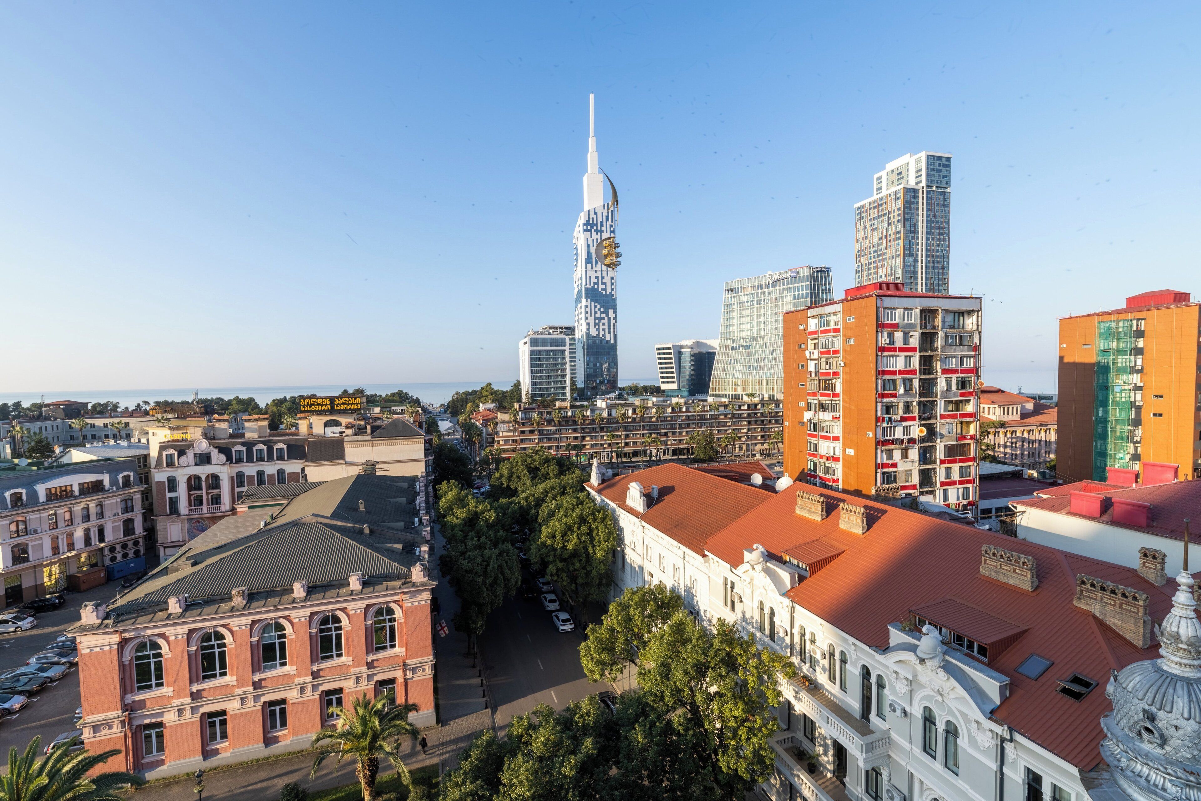 Un paisaje urbano con un moderno rascacielos destacado, edificios históricos y una combinación de estructuras residenciales y comerciales.