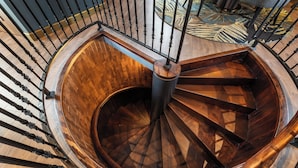 Eine Wendeltreppe mit Holzstufen und schwarzen Metallgeländern.
