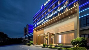 A hotel with a modern facade, large glass windows, and a prominent entrance with a covered walkway. - Holiday Inn Express Guangzhou Baiyun Airport T2 by IHG (Guangzhou)