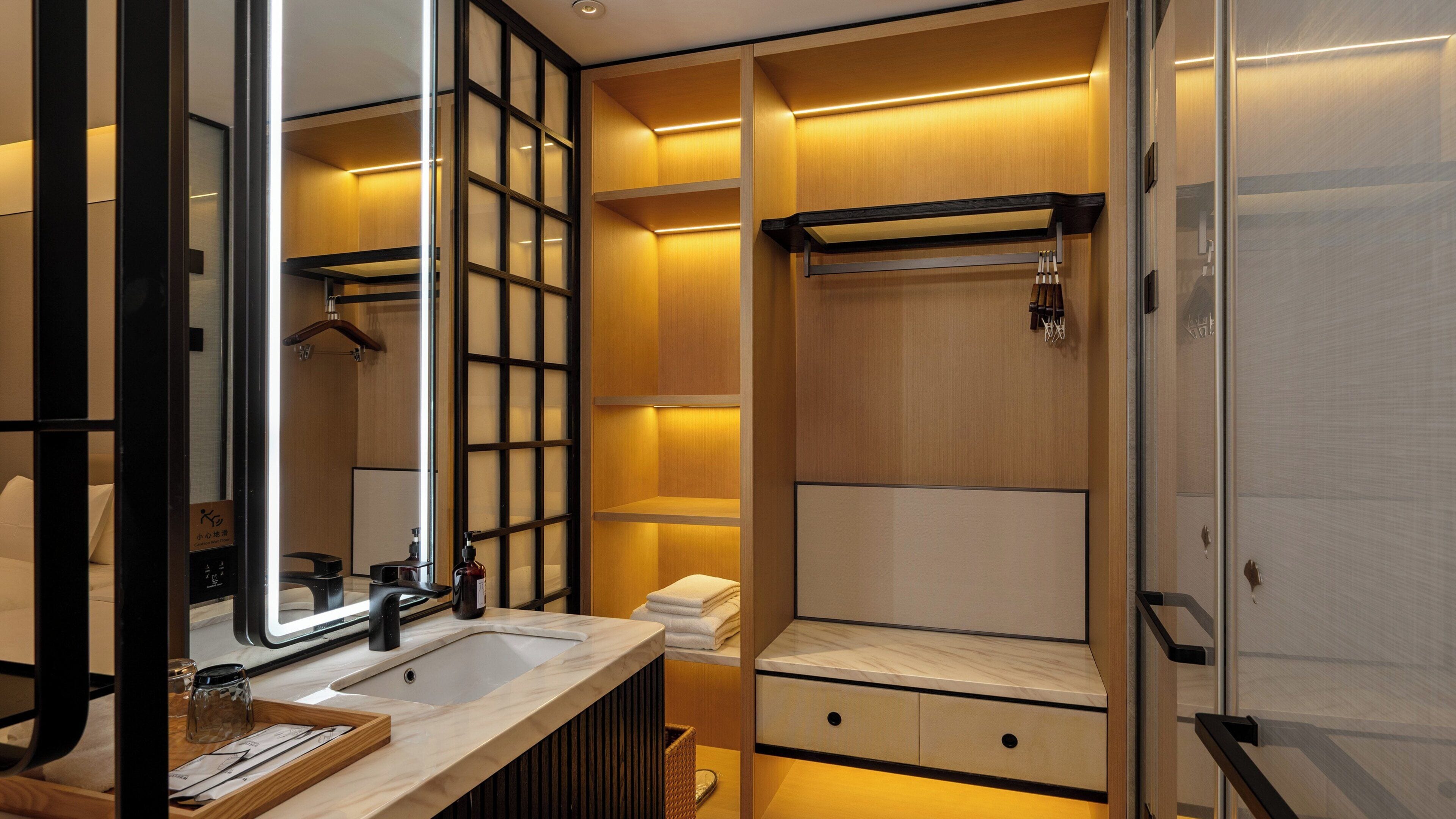 Un baño moderno con un espejo grande, un lavabo y una zona de ducha.