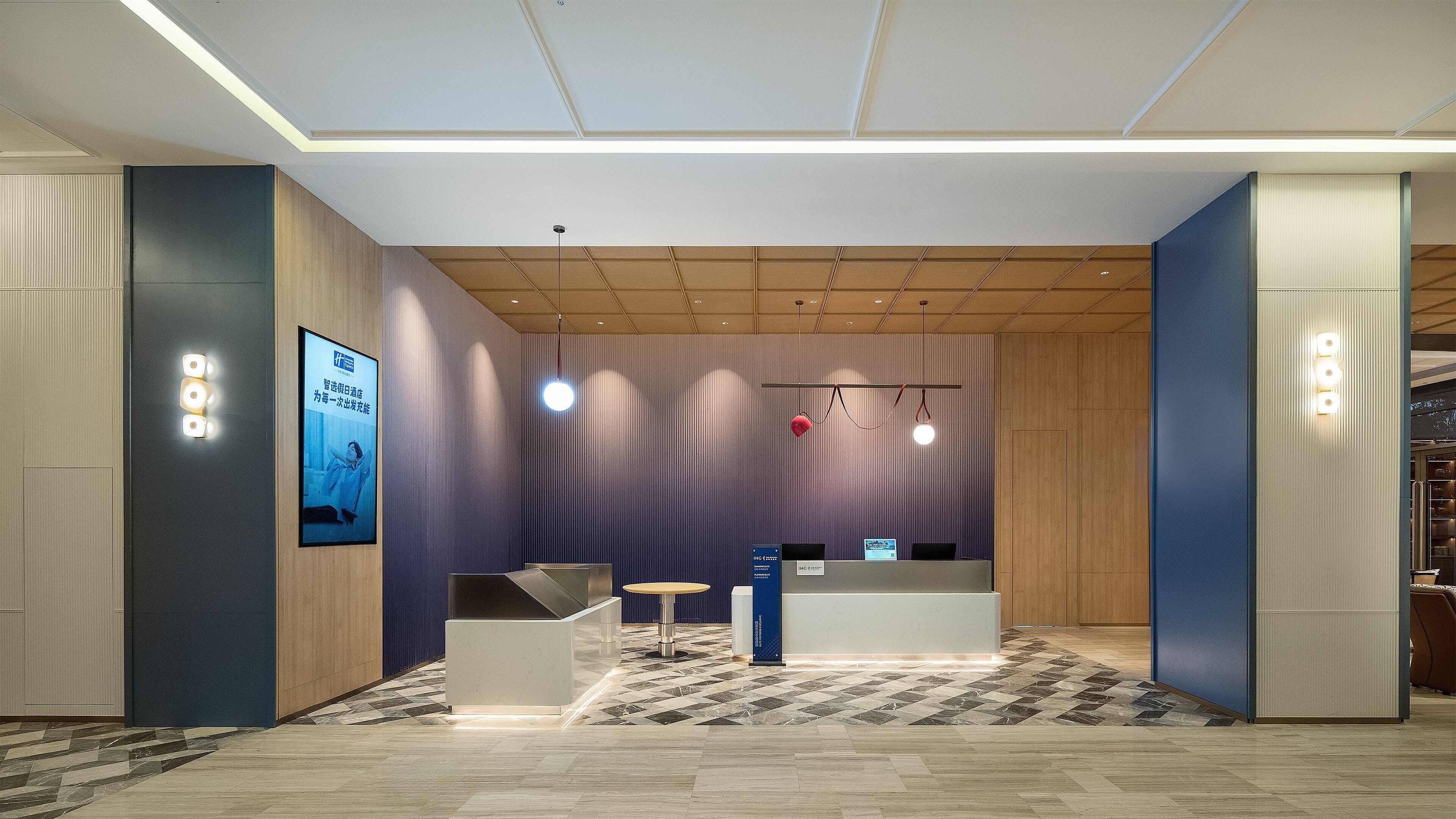 A modern reception area with a check-in counter, seating area, and a large poster on the wall.