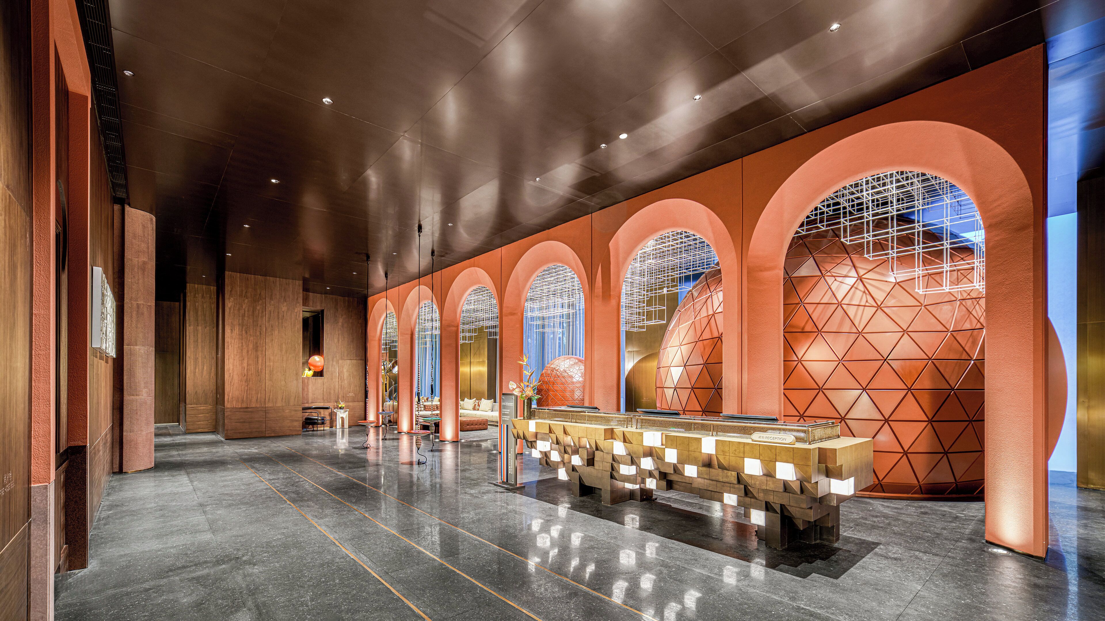 A spacious lobby with a reception desk, arched windows, and a geometric wall design.