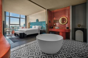 Une chambre d’hôtel moderne avec un grand lit, une baignoire et une vue sur la ville.