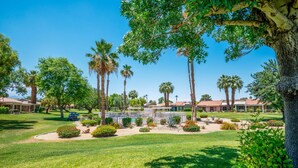 A well-maintained resort with multiple bungalow-style buildings, a central pool area, and lush landscaping.
