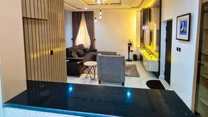 Una sala de estar moderna con un sofá, una mesa de centro y un comedor con mostrador de cocina.