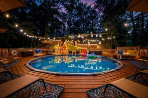 A swimming pool with a wooden deck, lounge chairs, and string lights. - ATL Cascade Oasis - Pool Spa Arcade Pool Tbl (Atlanta)
