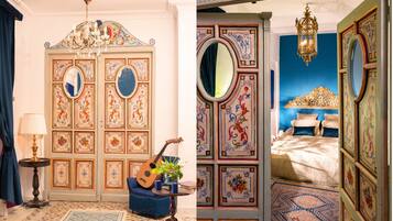 A room with a large ornate door, a guitar, a lamp, and a blue sofa.