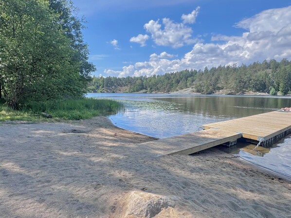 Een uitzicht op het meer met een houten steiger die in het water reikt, omgeven door dicht bos.