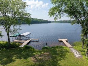 A lakeside dock with a covered seating area and a stone pathway leading to it. - Modern Lakehouse Retreat on Lake Namakagon With Private Hot Tub (Cable)