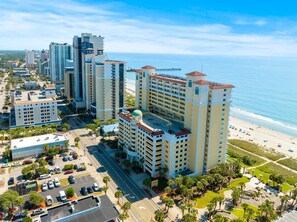 Un hotel moderno con un patio central, junto a la playa.