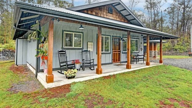 A modern house with a covered porch, large windows, and a stone foundation. - Cozy Volcano Room 🌋 (Volcano)