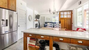 A modern kitchen with a central island, stainless steel appliances, and a cozy seating area with a sofa and a fireplace. - Cozy Volcano Room 🌋 (Volcano)
