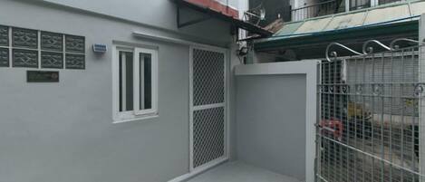 A gated area with a metal fence, a door, and a window.