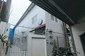 A building with a gated entrance, a visible number '304', and a blue circular sign on the wall. - Quintana Bunkhouse Manila (Manila)