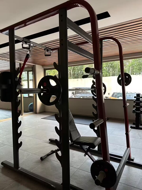 A gym with weightlifting equipment, including a squat rack and benches.