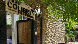 A restaurant named 'COLIBRI PALOMINO' with a stone wall exterior and a wooden door. - Casa Colibri Palomino (Palomino)