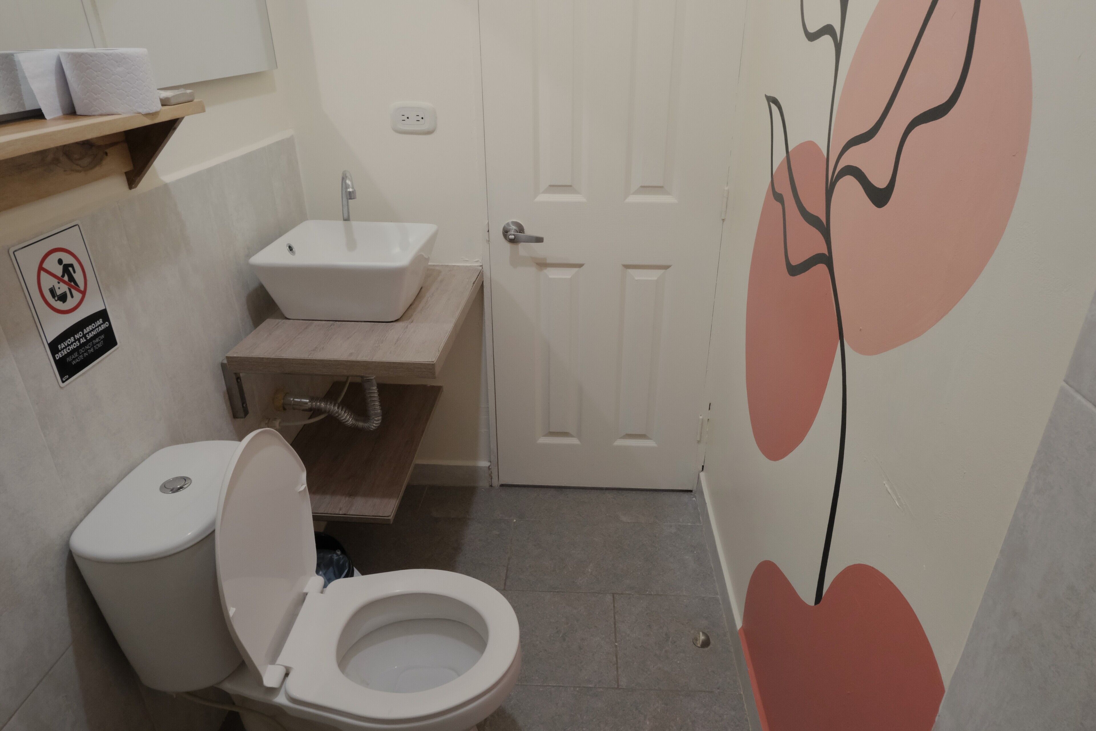 Un baño con inodoro, lavamanos y una puerta.