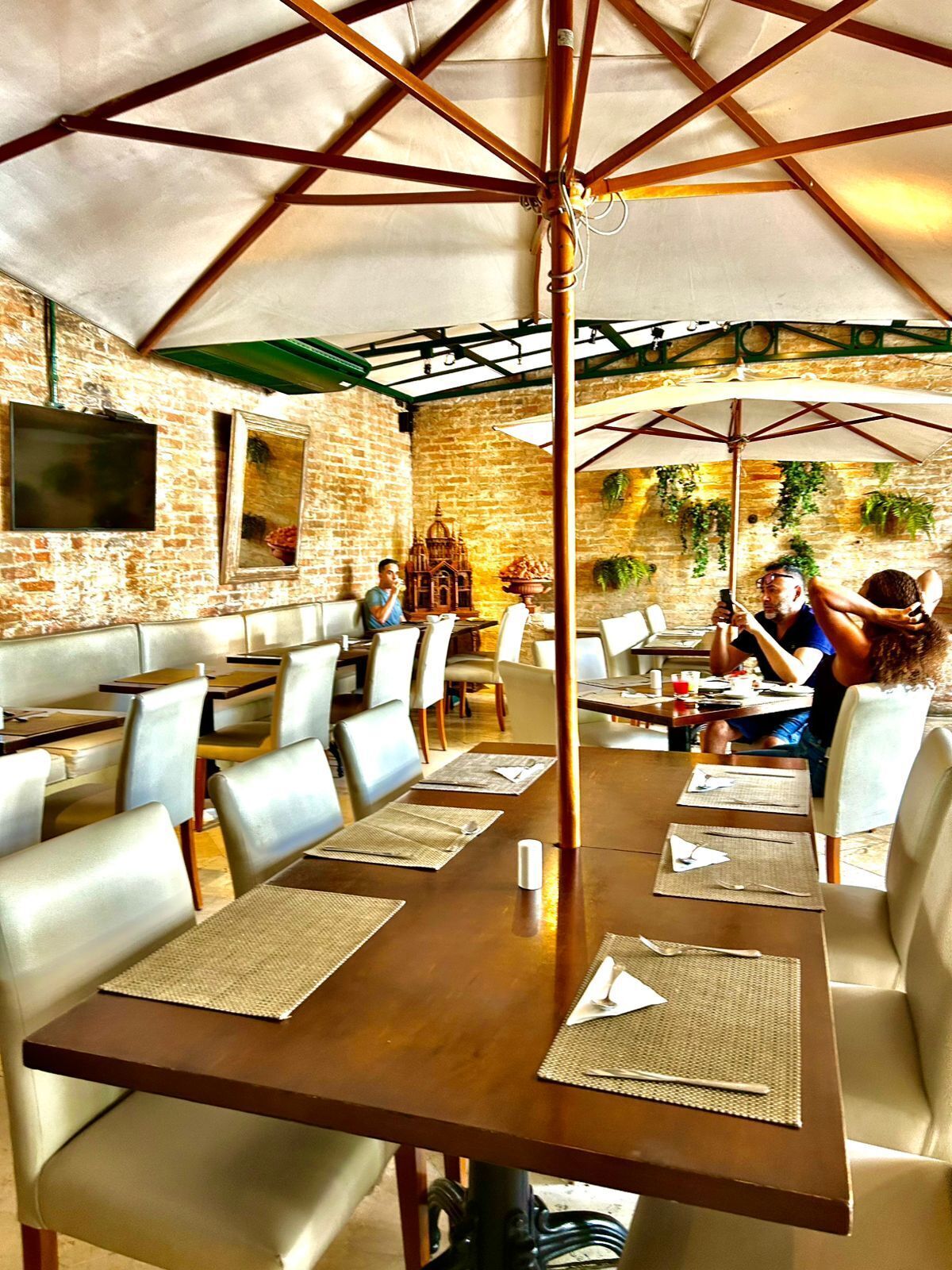Um restaurante com paredes de tijolo, mesas e cadeiras de madeira.