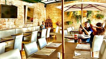 Um restaurante com paredes de tijolo, mesas e cadeiras de madeira.