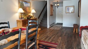A dining area with a wooden table, chairs, and a painting on the wall. There is a staircase leading to another room. - Magic on Lake San Cristobal  - Northshore #9 -  Quiet End Unit with Great Views (Lake City)