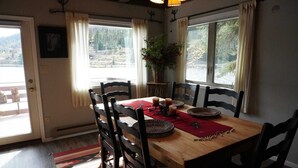 A dining area with a wooden table, six chairs, a red placemat, and candles. - Magic on Lake San Cristobal  - Northshore #9 -  Quiet End Unit with Great Views (Lake City)
