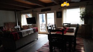 A cozy living room with a fireplace, a television, and a dining area with chairs and a table. - Magic on Lake San Cristobal  - Northshore #9 -  Quiet End Unit with Great Views (Lake City)