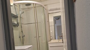A modern bathroom with a glass-enclosed shower, a toilet, and a sink with a mirror. - T2 apartment with mezzanine in the Marina, 3 minutes from the beach (Les Trois-Îlets)