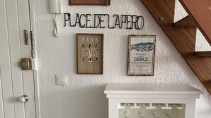 A wall with a mounted air conditioner, a wooden sign with 'PLACE DE LAPERO' text, and a wine rack with bottles. - T2 apartment with mezzanine in the Marina, 3 minutes from the beach (Les Trois-Îlets)