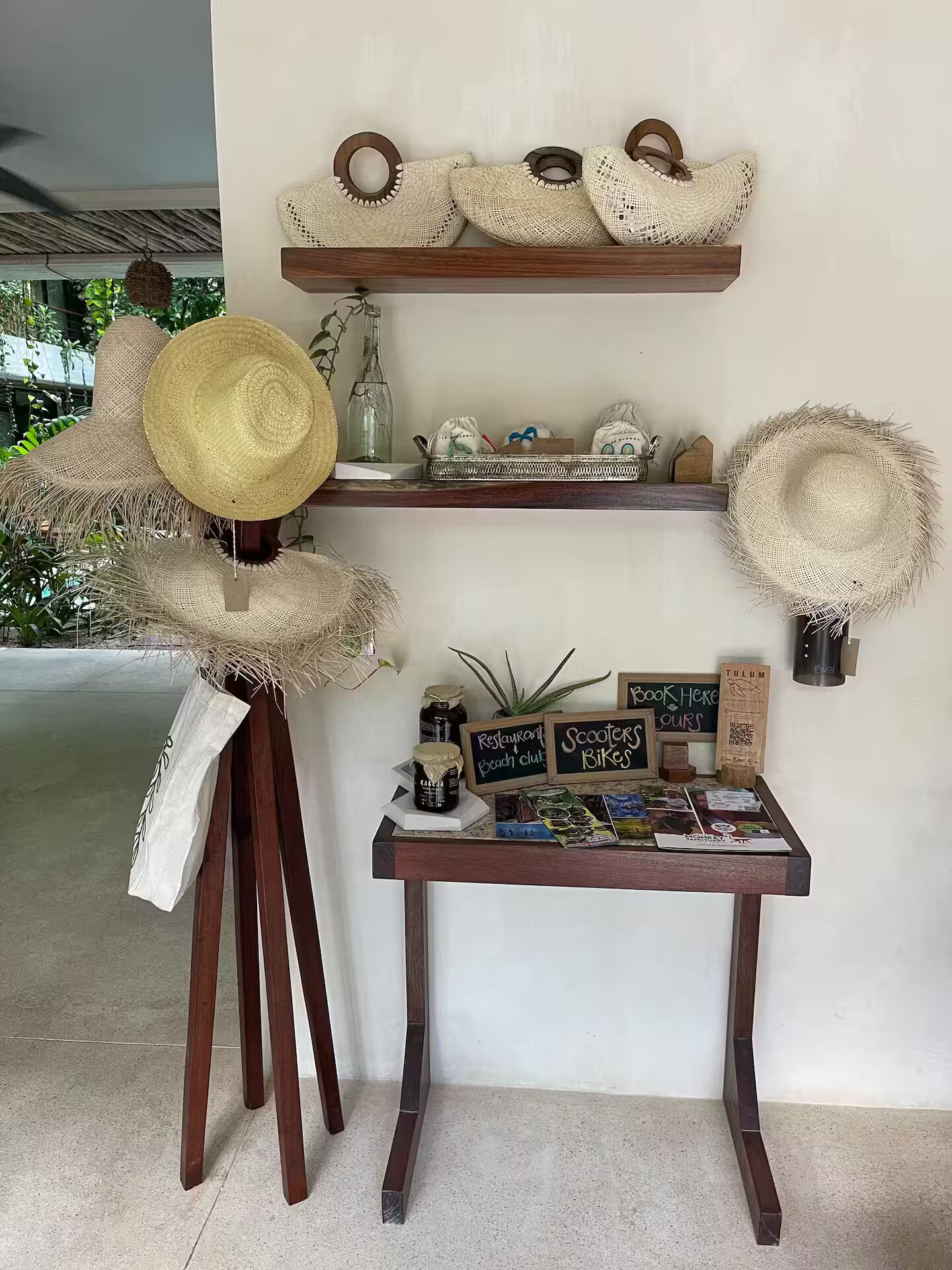 A wooden table with a chalkboard menu, surrounded by rustic hats and a small shelf with decorative items.