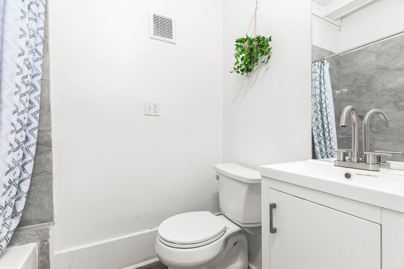 Une salle de bain équipée de toilettes, d’un lavabo et d’un rideau de douche.