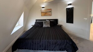 A bedroom with a large bed, a window, and a painting on the wall. - The Dome Home | 8 mins from Kanarra Falls (New Harmony)